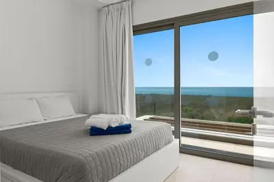 a bedroom with a bed and a large window at Serenity Waves Villa 7 in Sophtadhes
