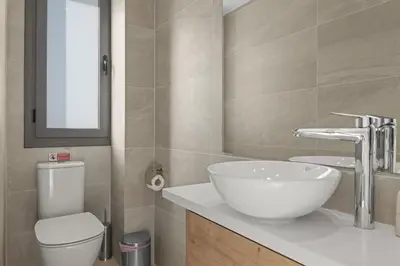 a bathroom with a white sink and a toilet at Serenity Waves Villa 3 in Sophtadhes