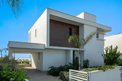 a white house with a fence in front of it at Serenity Waves Villa 3 in Sophtadhes