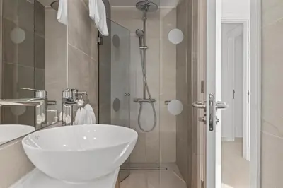 a bathroom with a white sink and a shower at Serenity Waves Villa 3 in Sophtadhes