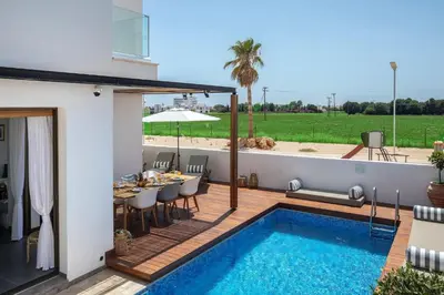 a patio with a table and a swimming pool at Extraordinary Protaras Villa Villa Leone 3 Bedrooms Private Outdoor Pool in Protaras