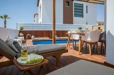 a patio with a table and chairs and a pool at Extraordinary Protaras Villa Villa Leone 3 Bedrooms Private Outdoor Pool in Protaras