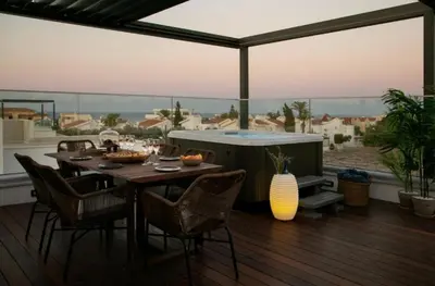 a deck with a table and chairs and a hot tub at Magnificent Protaras Villa Villa Chelsea 3 Bedrooms Private Outdoor Pool in Protaras