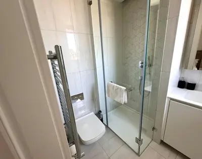 a bathroom with a toilet and a glass shower at Del Mar Beachfront 3 Bedroom 'A' Residence in Limassol