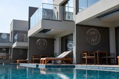 a swimming pool with chairs and tables next to a building at Exotic Sea Boutique Adults Only in Protaras