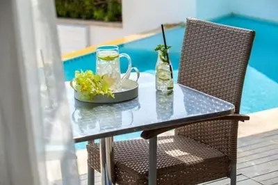 a table with a drink and a bowl of flowers on it at Premium Protaras Villa Villa Mine 2 Bedrooms Private Outdoor Pool in Protaras