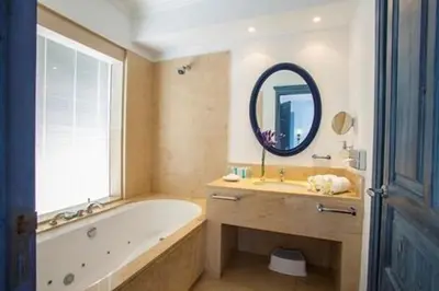 a bathroom with a tub and a sink and a mirror at Premium Protaras Villa Villa Mine 2 Bedrooms Private Outdoor Pool in Protaras