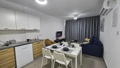 a kitchen and a living room with a table and chairs at STAY Arpa Suite in Protaras