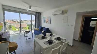 a living room with a table and a blue couch at STAY Arpa Suite in Protaras