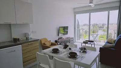a kitchen with a table and chairs and a kitchen with a view at STAY Arpa Suite in Protaras