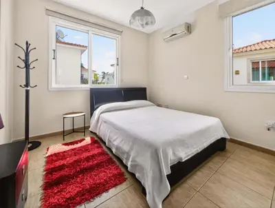 a bedroom with a bed and a red rug at Villa Ioli - 3BR Retreat near Kalamies Beach in Protaras