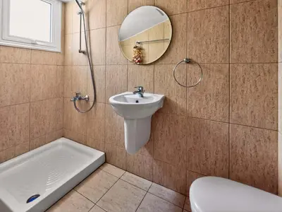 a bathroom with a sink and a toilet and a mirror at Villa Ioli - 3BR Retreat near Kalamies Beach in Protaras
