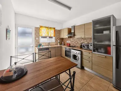 a kitchen with a wooden table and a dining room at Villa Ioli - 3BR Retreat near Kalamies Beach in Protaras