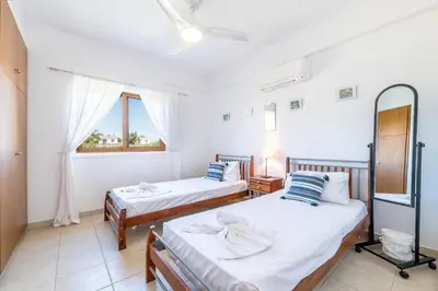 a bedroom with two beds and a window at Elena Gardens Villa in Ayia Napa
