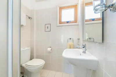 a white bathroom with a toilet and a sink at Elena Gardens Villa in Ayia Napa