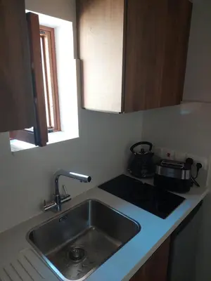 a kitchen counter with a sink and a stove at AROMA DRYOS in Kato Drys