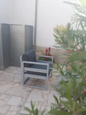 a blue chair sitting on a patio with plants at AROMA DRYOS in Kato Drys