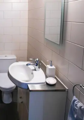 a bathroom with a sink and a toilet and a mirror at Central cozy apt in quiet area in Engomi in Nicosia