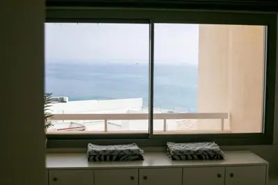 a window in a room with a view of the ocean at Palmove Luxurious Beachfront Apt in Larnaka