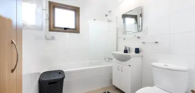 a white bathroom with a toilet and a tub and a sink at Potamos Villa - Villa Kymma 4 in Ayia Napa