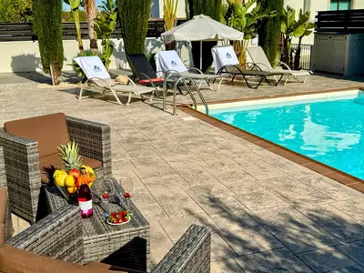 a table with fruit on it next to a swimming pool at Potamos Villa - Villa Kymma 4 in Ayia Napa