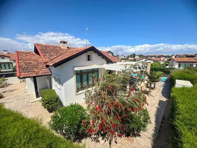 a white house with a red roof and some bushes at Potamos Villa - Villa Kymma 4 in Ayia Napa