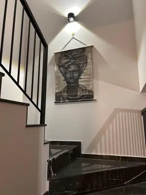 a staircase with a painting of a bust on the wall at Maroulla's Urban Beach Living in Limassol