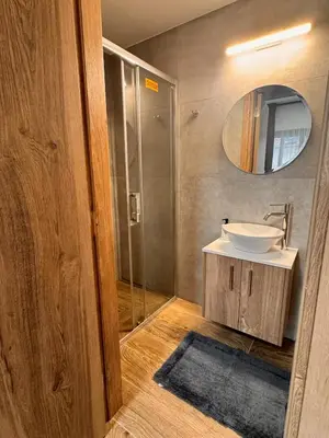 a bathroom with a sink and a shower with a mirror at Maroulla's Urban Beach Living in Limassol