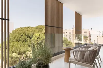 a balcony with chairs and a view of trees at White City Limassol in Limassol