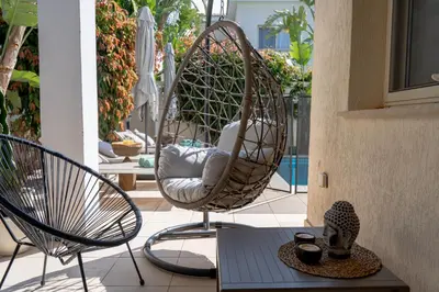 a patio with a swing chair and a table at Stylish & Picturesque Oasis Anthorina 2 in Protaras