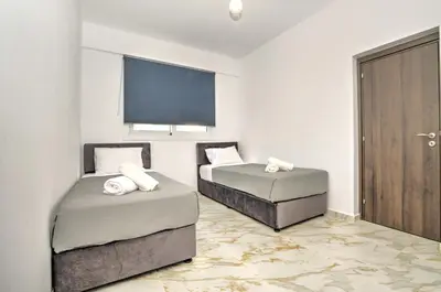 a bedroom with two beds and a large window at La Bella Nissi Villa in Ayia Napa