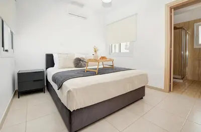 a bedroom with a bed with a table on it at La Bella Nissi Villa in Ayia Napa