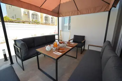 a dining room with a table and chairs and an umbrella at La Bella Nissi Villa in Ayia Napa