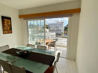 a dining room with a glass table and a balcony at Sunny 2 bedroom flat in Engomi in Engomi