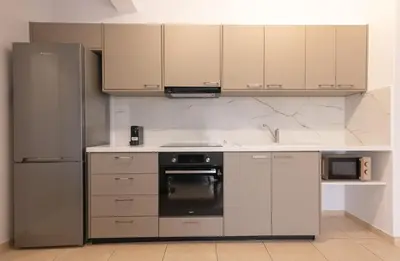 a kitchen with stainless steel appliances and white cabinets at Phaedrus Living Limassol Pyrgos Seaside Flat in Limassol