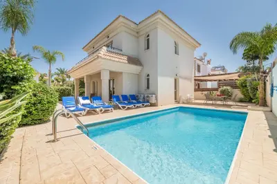 a villa with a swimming pool and a house at Villa Lindo in Protaras