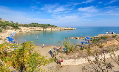 a beach with a bunch of people in the water at Villa Lindo in Protaras