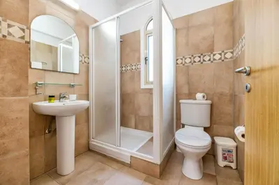 a bathroom with a shower and a toilet and a sink at Villa Lindo in Protaras