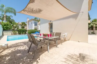 a patio with a table and chairs next to a pool at Villa Lindo in Protaras
