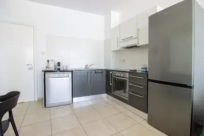 a kitchen with a refrigerator and a dishwasher at Prime Protaras Seafront Apt in Protaras
