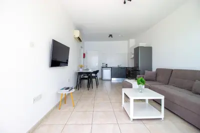 a living room with a couch and a table at Prime Protaras Seafront Apt in Protaras