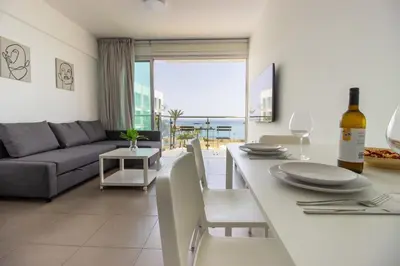 a kitchen and living room with a table and a couch at Stunning Sea-Views Apt, Protaras in Protaras
