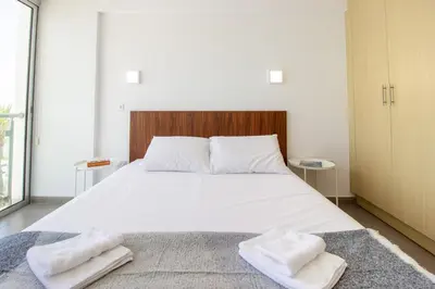 a bedroom with a large white bed with two towels at Stunning Sea-Views Apt, Protaras in Protaras