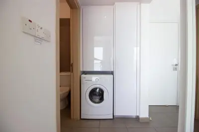 a bathroom with a washer and dryer in a room at Stunning Sea-Views Apt, Protaras in Protaras