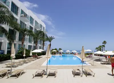 a pool at the resort with chairs and umbrellas at Stunning Sea-Views Apt, Protaras in Protaras
