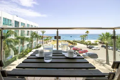 a table on a balcony with a view of the beach at Stunning Sea-Views Apt, Protaras in Protaras