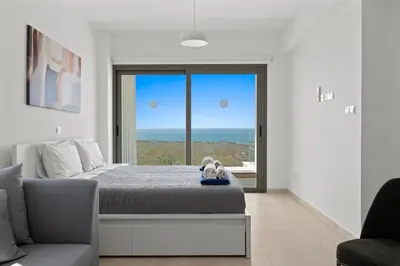 a bedroom with a bed and a large window at Serenity Waves Villa 6 in Sophtadhes