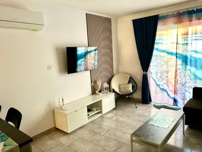 a living room with a tv on the wall at Nissi Golden Sands Apartment D01 in Ayia Napa