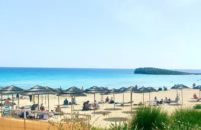 people on a beach with umbrellas and the ocean at Nissi Golden Sands Apartment D01 in Ayia Napa