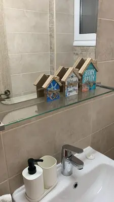 a bathroom with a sink with a shelf above it at Nissi Golden Sands Apartment D01 in Ayia Napa